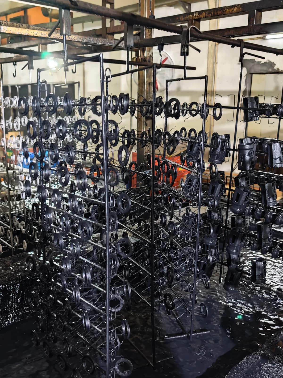 Multiple components suspended on metal processing racks.