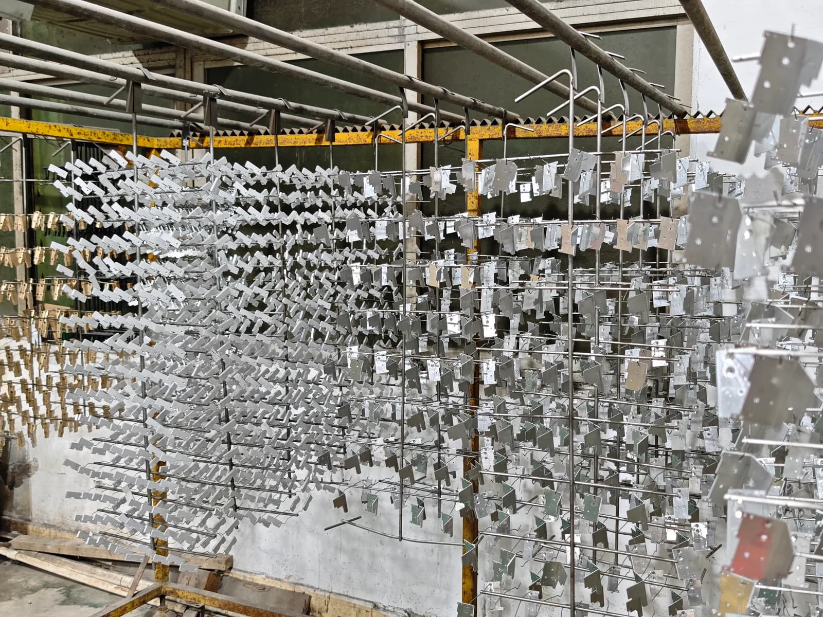 Large number of small metal components mounted on processing racks.